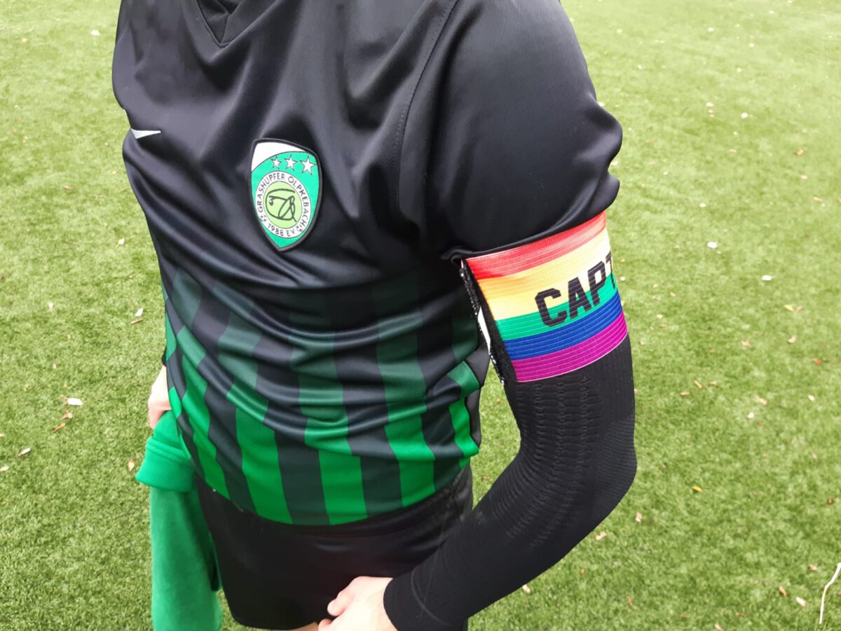 Grashüpfer-Spieler mit der Regenbogen-Kapitänsbinde