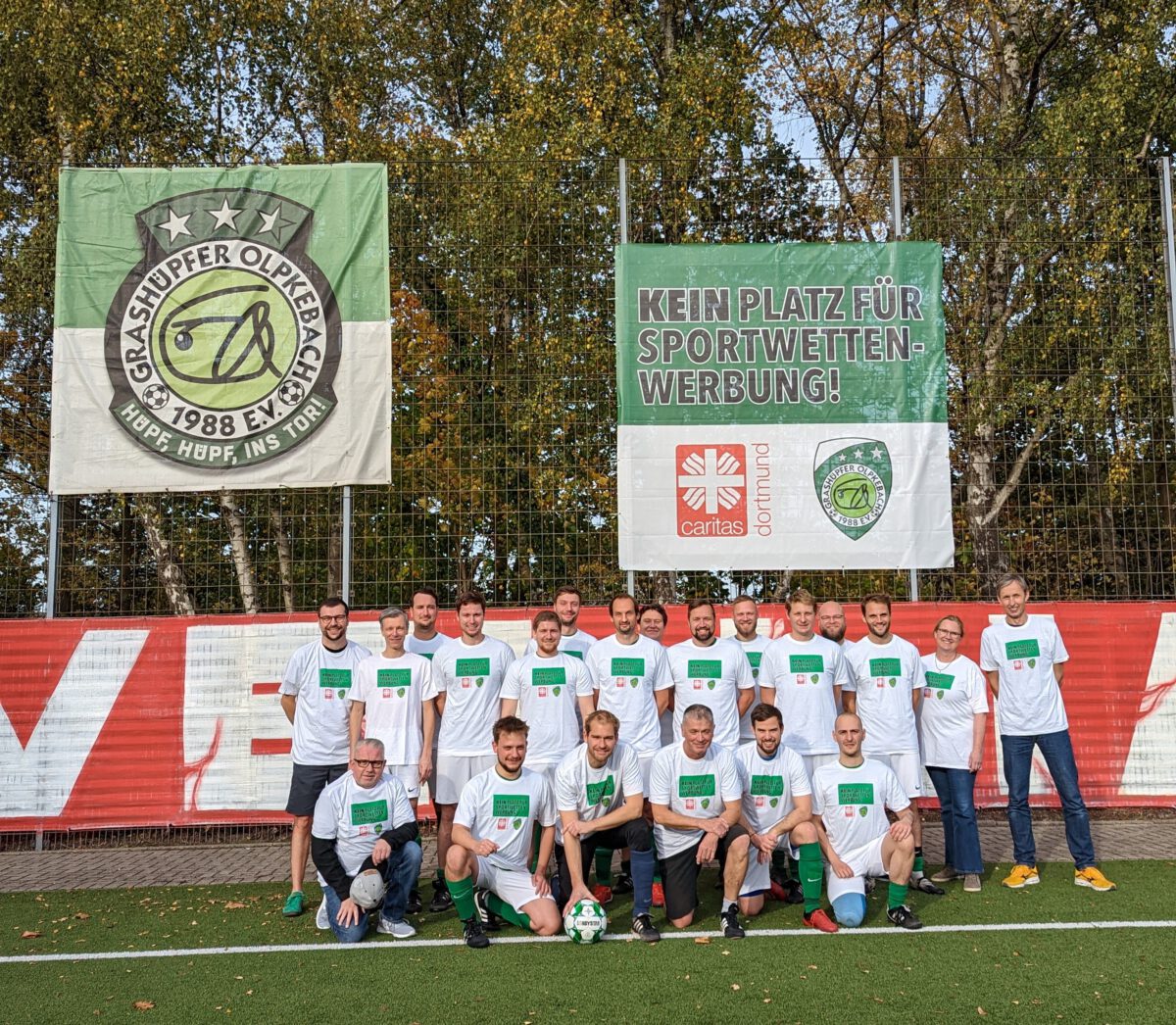 Die Mannschaft der Grashüpfer vor einem Banner mit der Aufschrift "Kein Platz für Sportwettenwerbung"